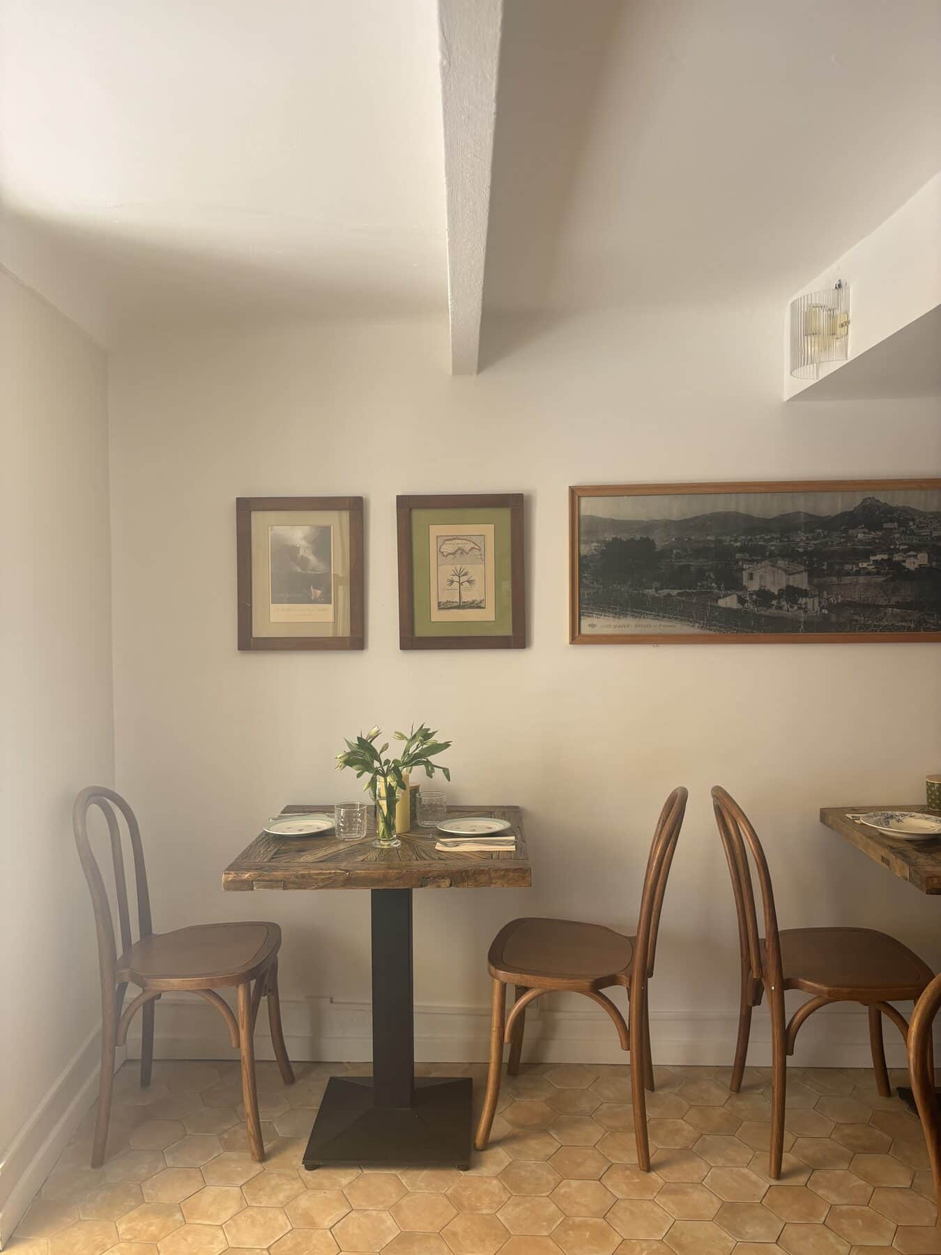 Mur du bistrot en accumulation de cadres anciens et objets chinés.