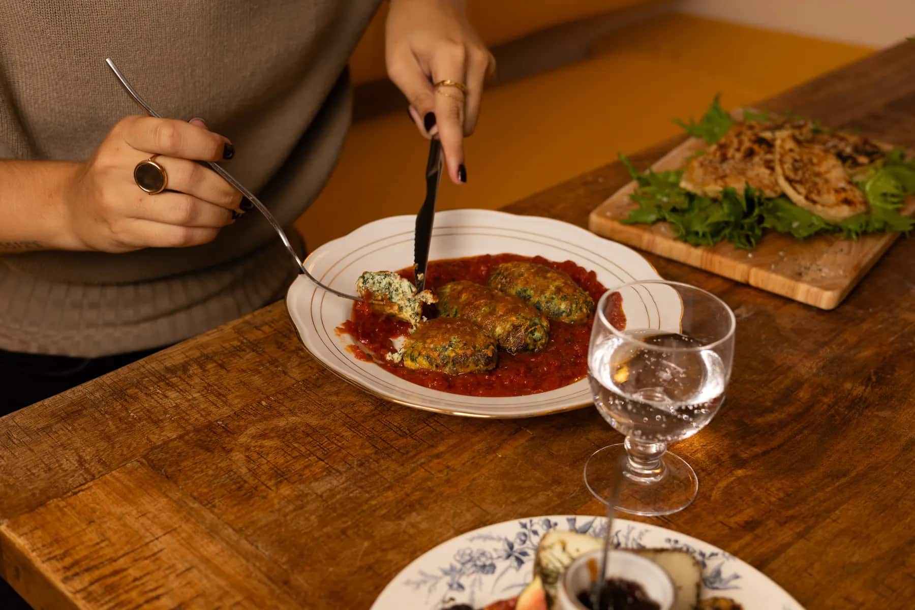 Les storzapretti servis à table, quenelles aux herbes sur sauce tomate.